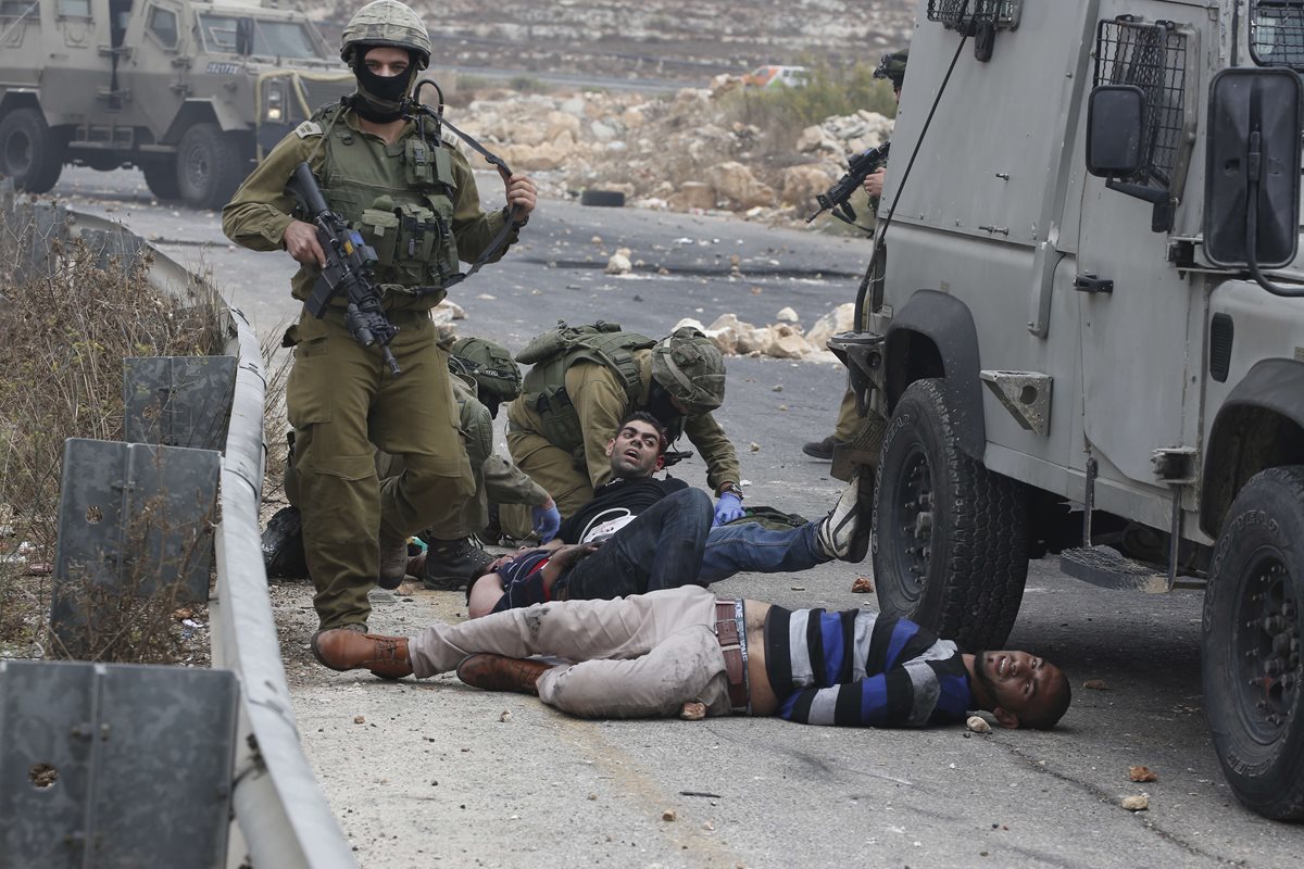 Soldados israelíes detienen a manifestantes palestinos durante la escalada de violencia que ha tenido lugar en Israel. (Foto Prensa Libre: AFP).