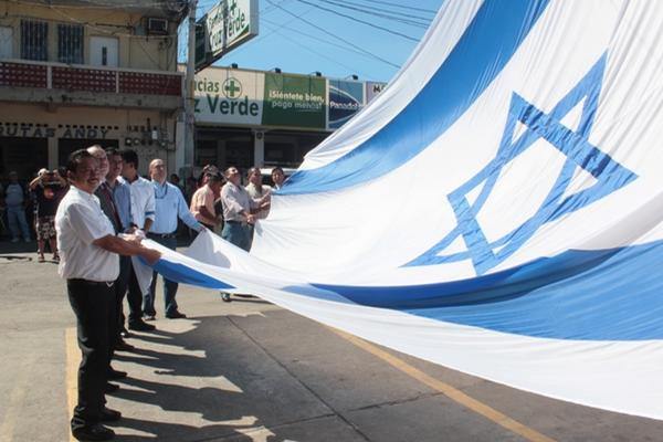 Autoridades de Puerto San José, pastores y representantes de la Embajada de Israel izan la bandera de ese país. (Foto Prensa Libre: Melvin Sandoval)