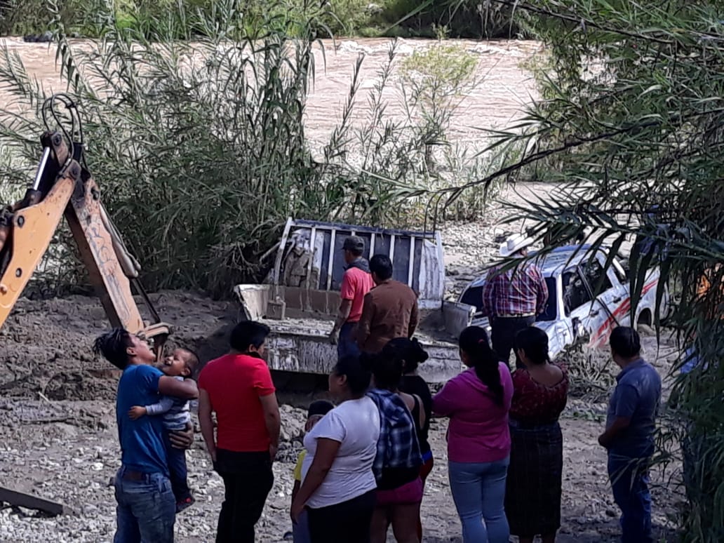Vecinos observan dos de los vehículos que fueron arrastrados por la correntada en Sacapulas. (Foto Prensa Libre: Héctor Cordero).