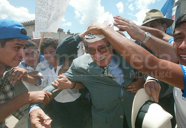 Ríos Montt es resguardado de la lluvia de piedras y palos el 14 de junio de 2003. (Foto: Hemeroteca PL)