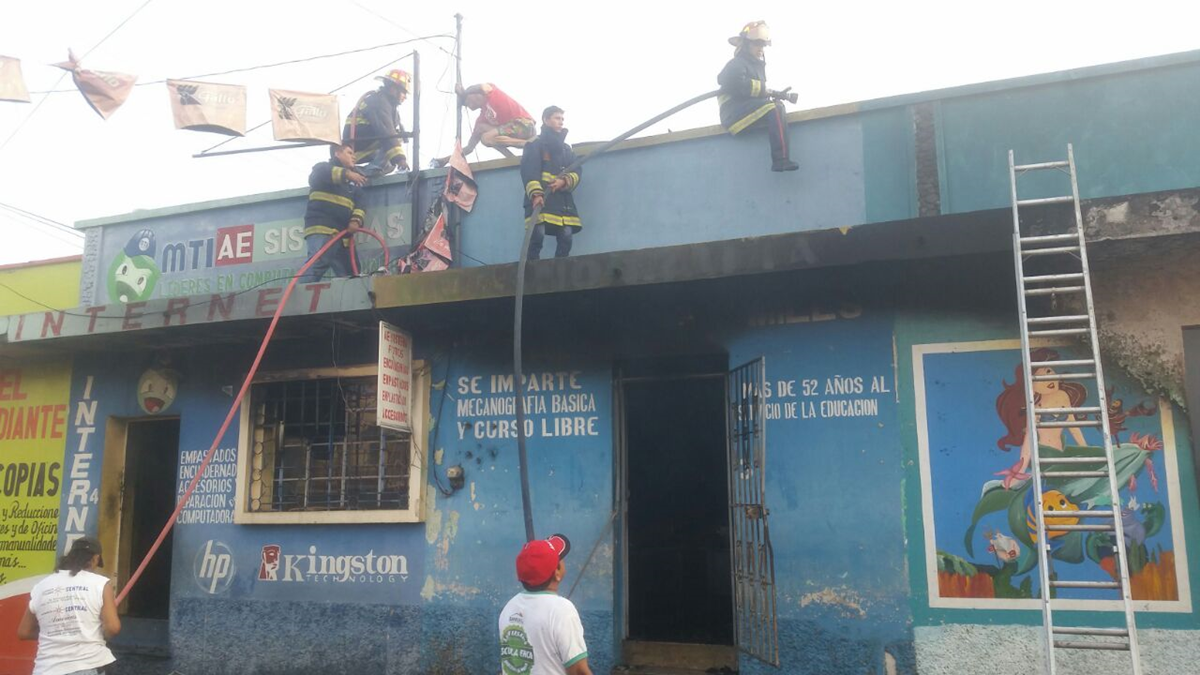 Socorristas extinguen el fuego en los locales comerciales de Cuyotenango. (Foto Prensa Libre: Cristian Icó)