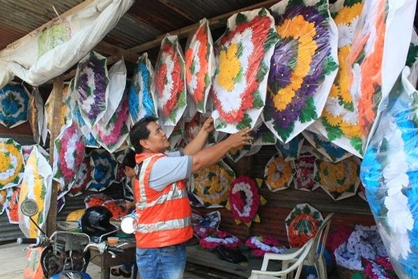 Cliente observa una corona en una de las ventas instaladas en el mercado de flores, en Escuintla. (Foto Prensa Libre: Melvin Sandoval) <br _mce_bogus="1"/>