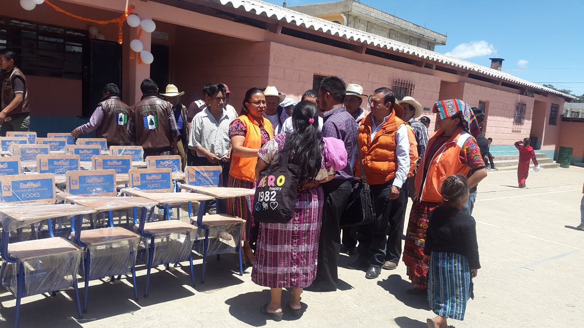 La candidata Ajín Tecún y los que la acompañan llegan con chalecos color naranja a hacer la entrega de pupitres en la escuela de la aldea Patachaj, de San Cristóbal Totonicapán. (Foto Prensa Libre: Lucero Sapalú)