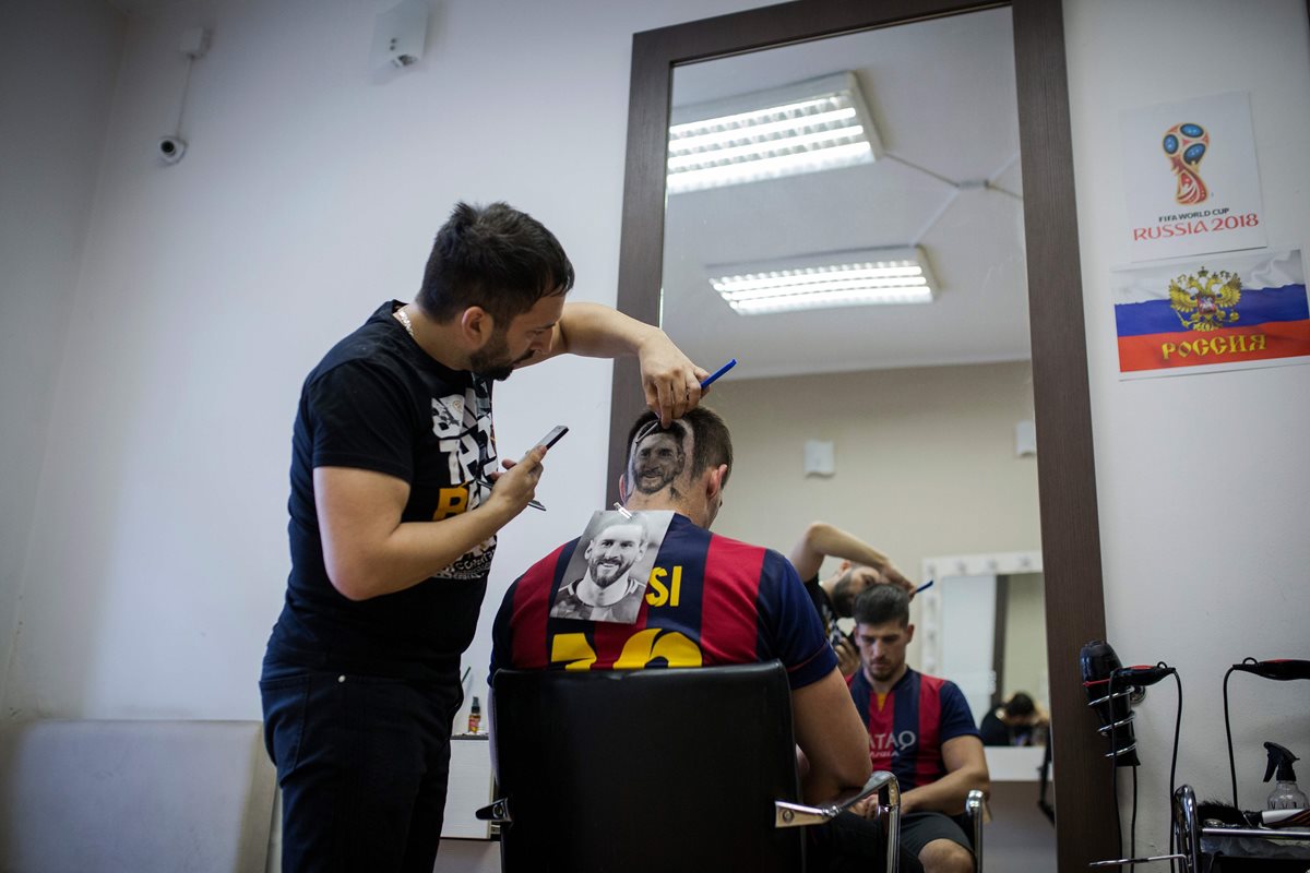 El estilista serbio Mario Hvala realiza un corte de cabello con la forma del rostro de Leo Messi. (Foto Prensa Libre: AFP)
