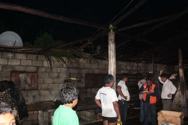 Un grupo de vecinos de Las Lisas permanece en una de la viviendas dañadas por el fuerte viento. (Foto Prensa Libre: Oswaldo Cardona).  <br _mce_bogus="1"/>