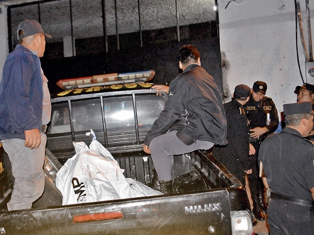 Autoridades del SP y agentes de la PNC retiran los cuerpos de los reos que fueron hallados sin vida. (Foto Prensa Libre: Oswaldo Cardona)