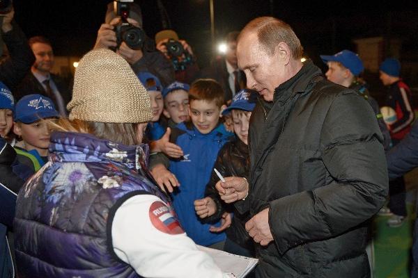 El presidente ruso, Vladimir Putin, firma autógrafos a varios jóvenes rusos durante una actividad efectuada ayer.  (Foto Prensa Libre: EFE)