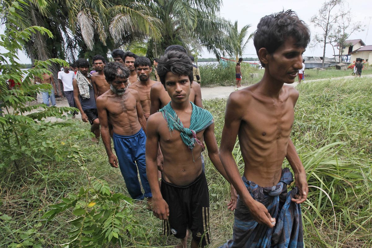 Con evidentes signos de desnutrición aguda, unos birmanos caminan después de tocar tierra en una provincia de Tailandia. (Foto Prensa Libre: AP).