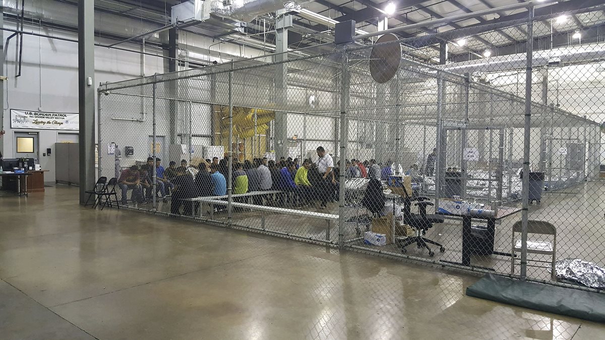 Varias personas que cruzaron la frontera ilegalmente en el sur de EE. UU. son detenidas en el Centro de Procesamiento Central en McAllen, Texas. (AFP)