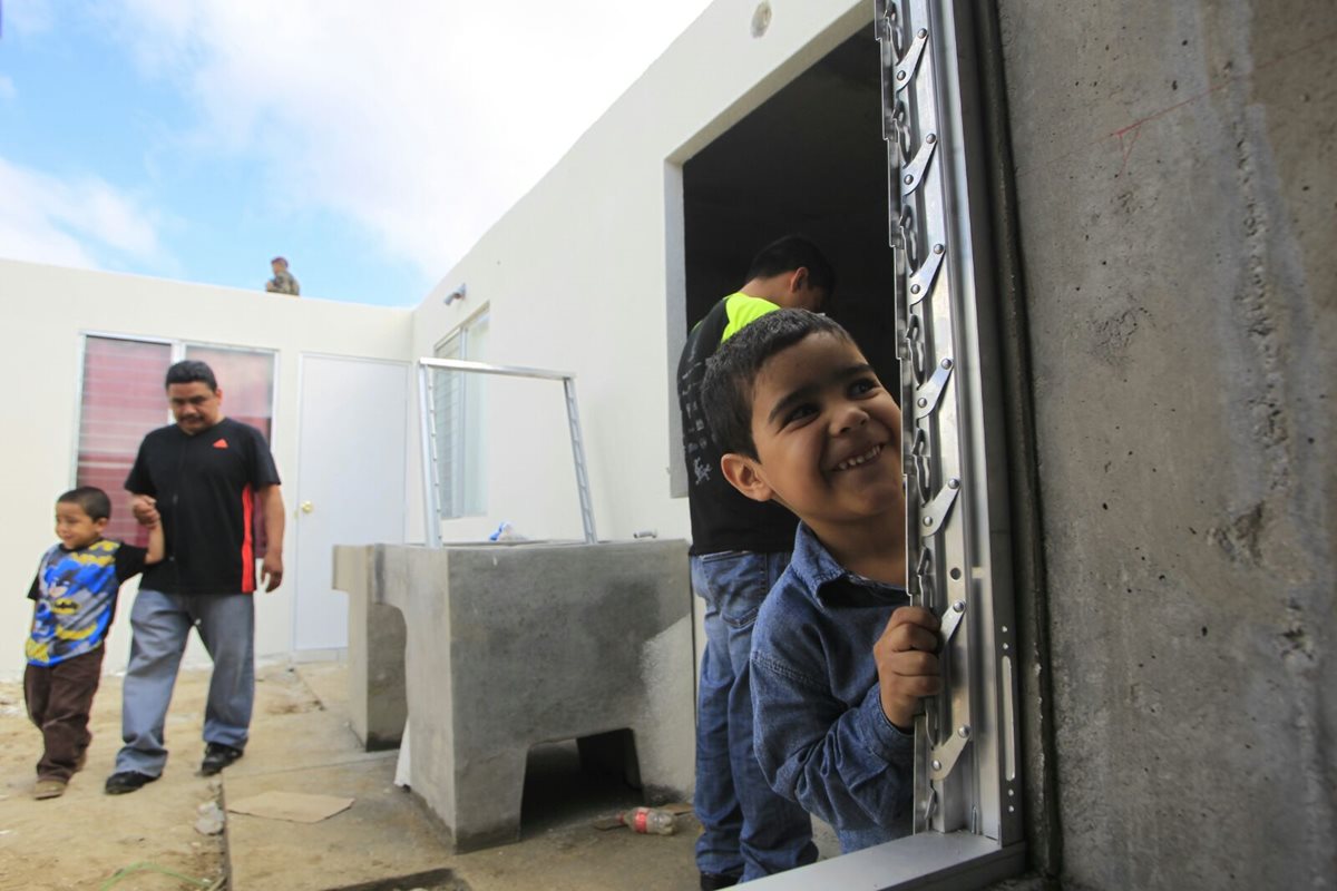 Niños y adultos recorren las casas que sirven de modelo en el proyecto Querida Familia. (Foto Prensa Libre: Edwin Bercián)