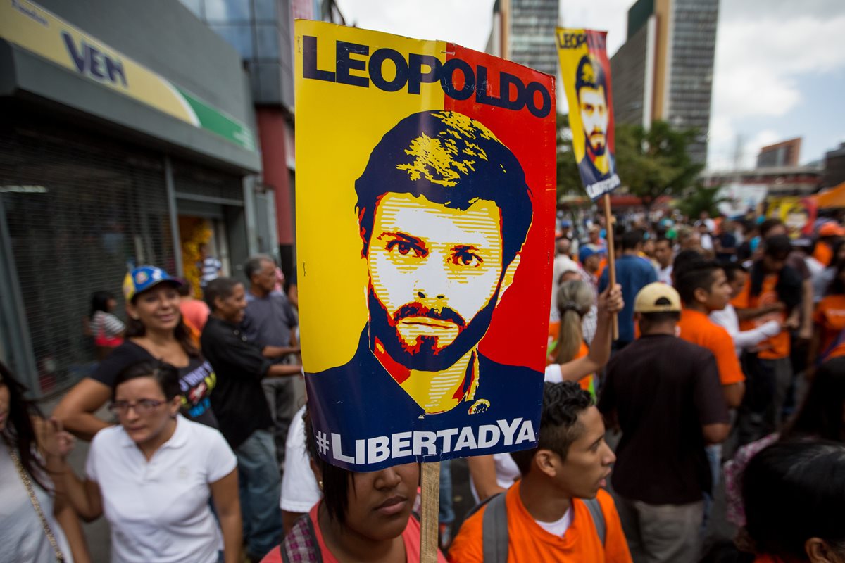 Simpatizantes del líder opositor venezolano, Leopoldo López, portan una pancarta con su fotografía en Caracas. (Foto Prensa Libre: EFE).