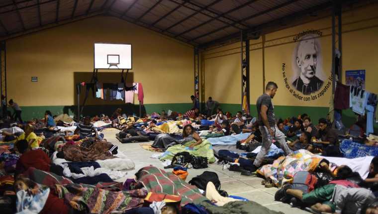 Hondureños duermen en la Casa del Migrante, zona 1, donde suelen pernoctar una noche para, al día siguiente, continuar su travesía hacia EE. UU. (Foto Prensa Libre: AFP)