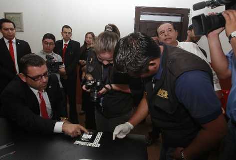 Manuel Baldizón muestra a agentes del Ministerio Público el teléfono  donde recibió amenazas.