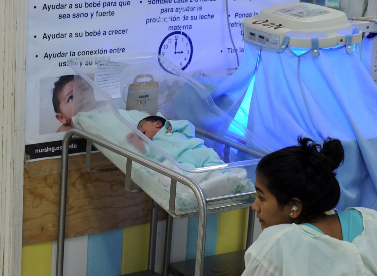 Una mujer observa a su hijo recién nacido en un hospital de Honduras. (Foto Prensa Libre: AFP).