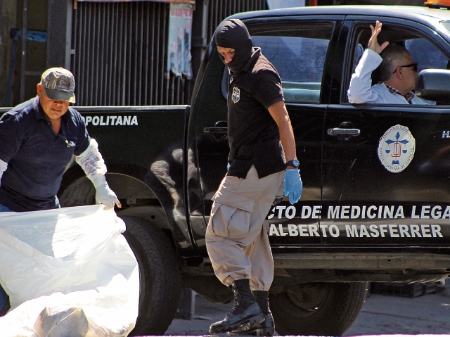 Efectivos de la Policía forense salvadoreña trabajan en la escena del crimen, donde un joven fue asesinado por pandilleros, en San Salvador, El Salvador. (Foto Prensa Libre: AFP)