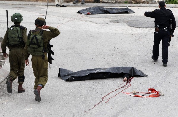 El cuerpo del palestino baleado por un soldado israelí en una calle de Hebrón. (Foto Prensa Libre: AFP)