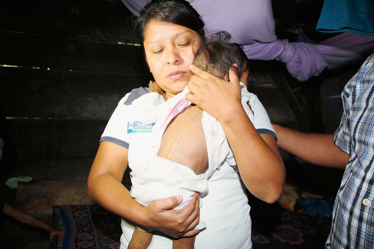 Trabajadora de Salud sostiene a la menor rescatada en Nuevo San Carlos, Retalhuleu. (Foto Prensa Libre: Rolando Miranda)