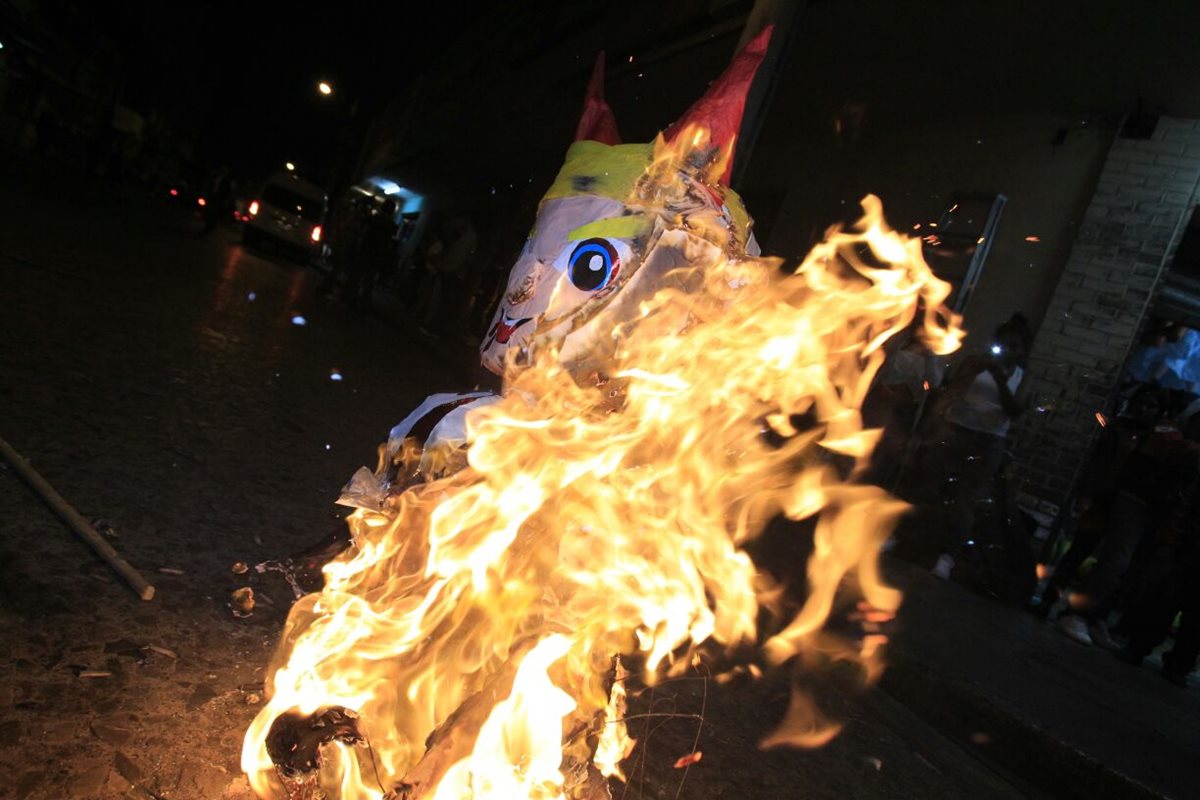 Una piñata con el rostro de Donald Trump fue quemada por vecinos en el parque Colón, zona 1 capitalina. (Foto Prensa Libre: Carlos Hernández)