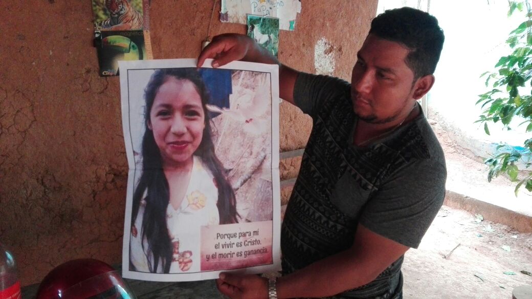 Un vecino sostiene una foto de Ángela Santiago Hernández de 12 años. (Foto Prensa Libre: Mario Morales)