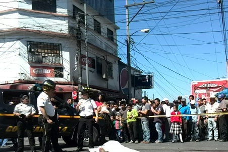 Curiosos observan el cuerpo de un hombre, quien fue degollado en el mercado el Guarda, zona 11. (Foto Prensa Libre: Estuardo Paredes)