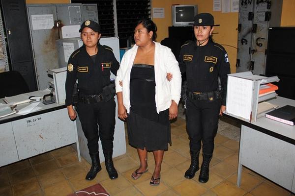 Dos agentes de la PNC trasladan a la sede policial a Silvia Yohana Vásquez. (Foto Prensa Libre: Edwin Paxtor)