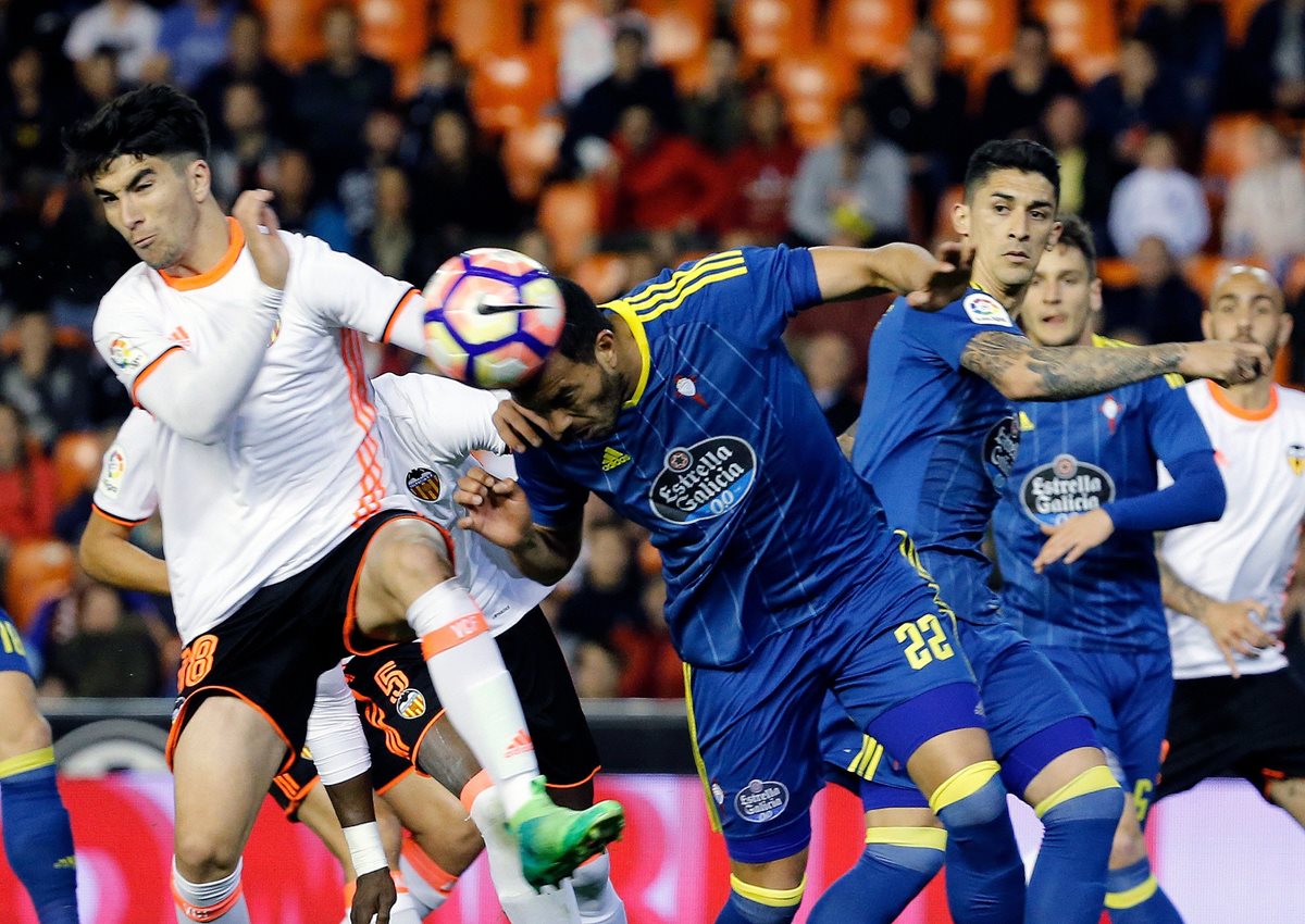 El defensa argentino del Celta de Vigo Gustavo Daniel Cabral (c) y el mediocampista del Valencia Carlos Soler (i) luchan por el balón en el duelo que terminó ganando el Valencia. (Foto Prensa Libre: EFE)