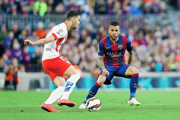 Dani Alves disputa el balón con Edgar Méndez, en el juego de ayer entre el Barcelona y Almería. (Foto Prensa Libre: EFE)