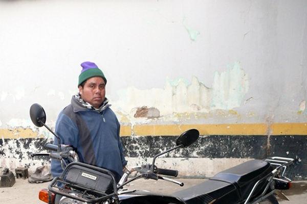Rigoberto Winac Gómez permanece junto a la motocicleta que pretendía robar en Santa Cruz del Quiché. (Foto Prensa Libre: Óscar Figueroa)