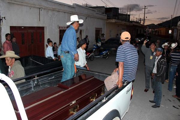 Familiares del transportista Leonel Hernández Lorenzo trasladan el cadáver. (Foto Prensa Libre: Hugo Oliva)