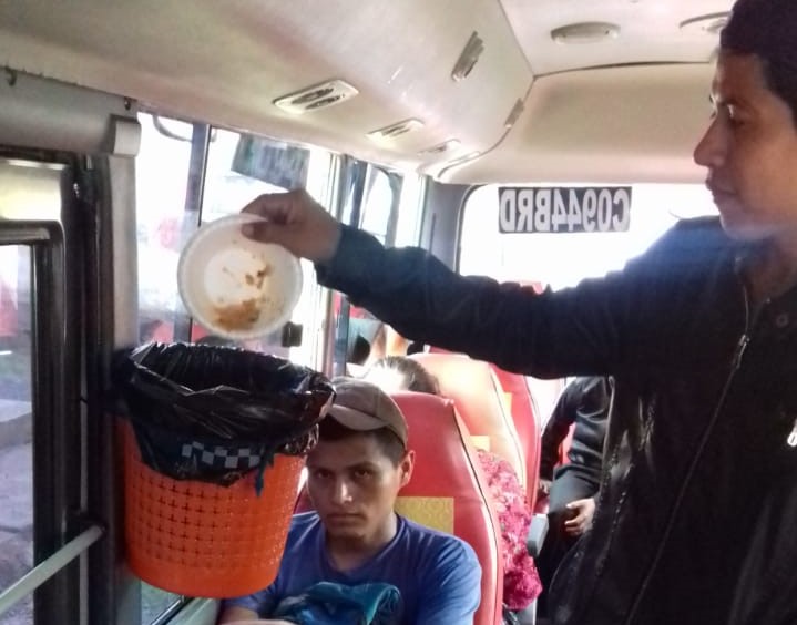 Un pasajero deposita basura en el recipiente colocado en el bus que cubre la ruta entre La Tinta Y Cobán, Alta Verapaz. (Foto Prensa Libre: Cortesía).