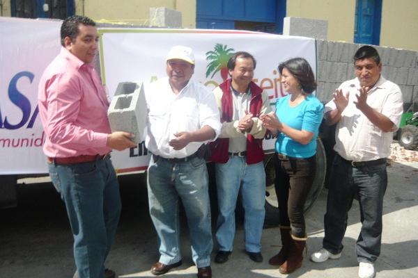 Juan Carlos Ochoa (Izq), alcalde de Esquipulas Palo Gordo, recibe el primer block  de manos de Huberto Orozco, representante de la Bananera Nacional y Agroaceite S.A. (Foto Prensa Libre: Genner Guzmán)