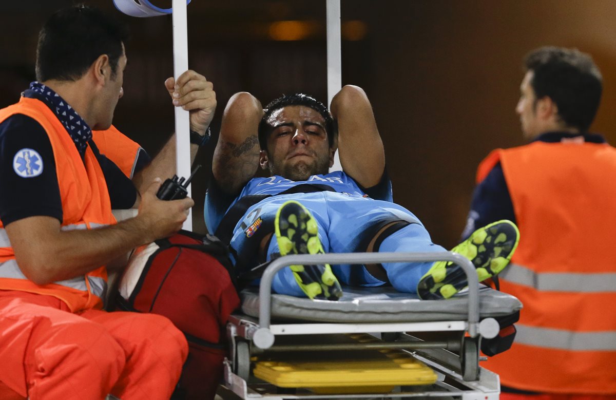 Rafinha mientras recibe asistencia médica, luego de la fuerte entrada de Radja Nainggolan en el partido de ayer. (Foto Prensa Libre: AP)
