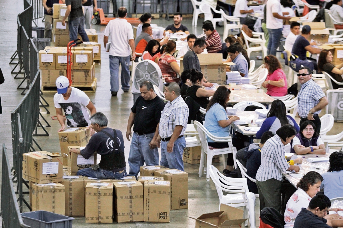 Los 250 colaboradores del TSE revisan la cantidad de papeletas de votación en el centro de logística del Parque de la Industria, en la zona 9. (Edwin Bercián)