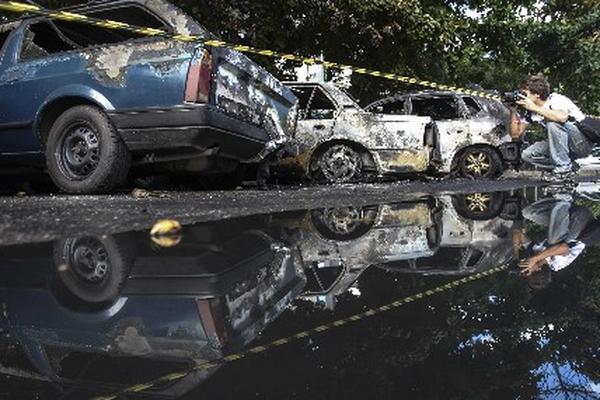 Desconocidos incendiaron tres vehículos en el conjunto de favelas del Alemao. (Foto Prensa Libre:EFE)