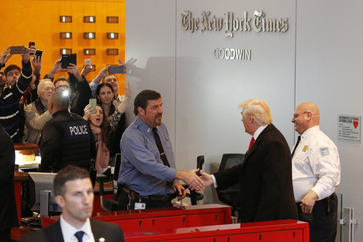Donald Trump saluda a personal del diario New York Times al retirarse de las instalaciones. (Foto Prensa Libre: AP).