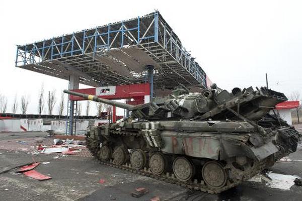 Un tanque del ejército ucraniano dañado en inmovilizado en una estación de servicio. (Foto Prensa Libre: AFP)