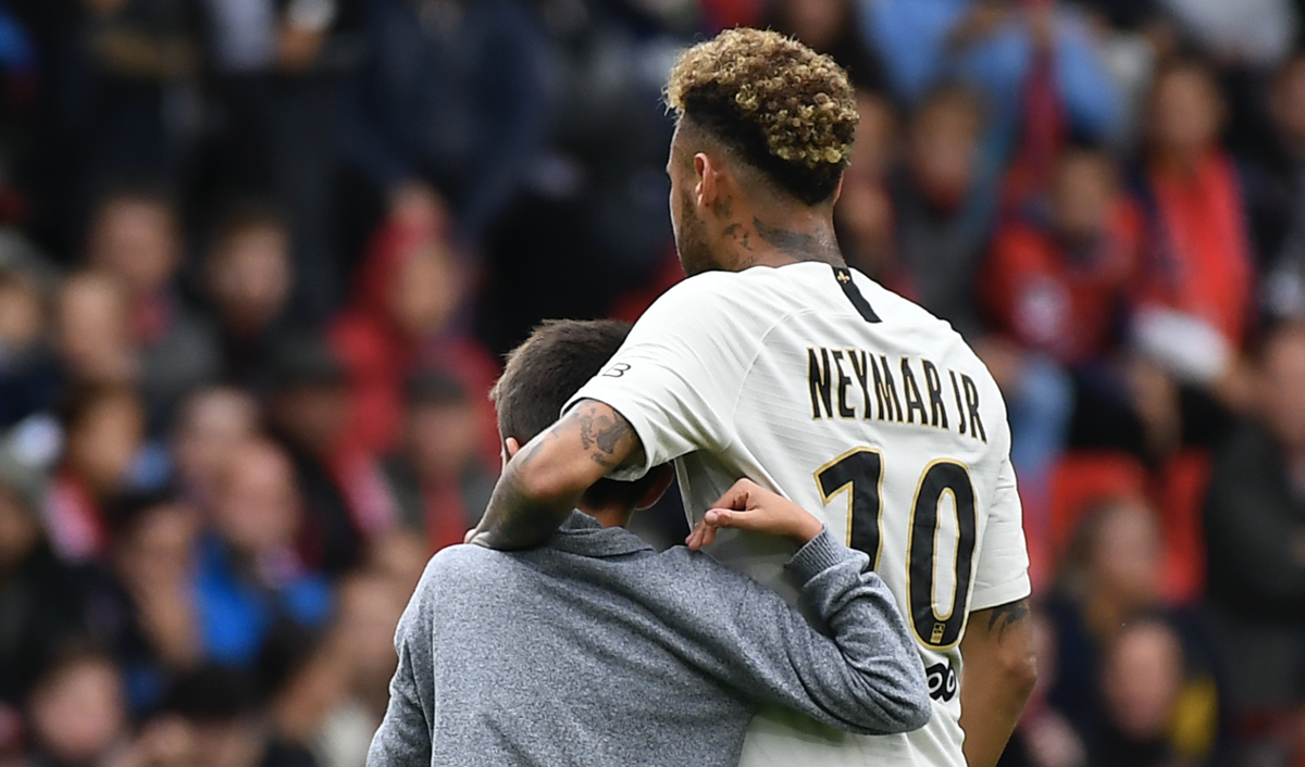 Neymar abraza a un pequeño admirador que se coló en el campo durante el partido Rennes - PSG. (Foto Prensa Libre: AFP)