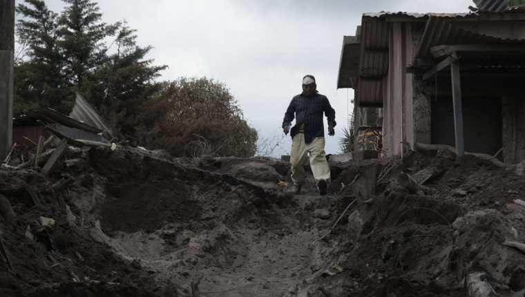 Un residente camina entre los escombros en la población de El Rodeo, la cual aún permanece sepultada tras la erupción del Volcán de Fuego. (Foto Prensa Libre: EFE)