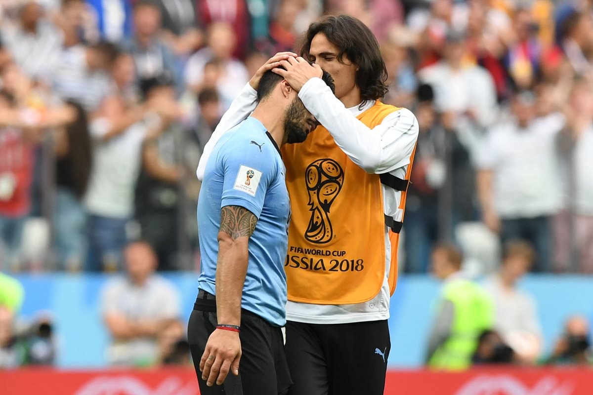 Edinson Cavani consuela a Luis Suárez, después de que Uruguay quedara eliminada ante Francia. (Foto Prensa Libre: AFP)
