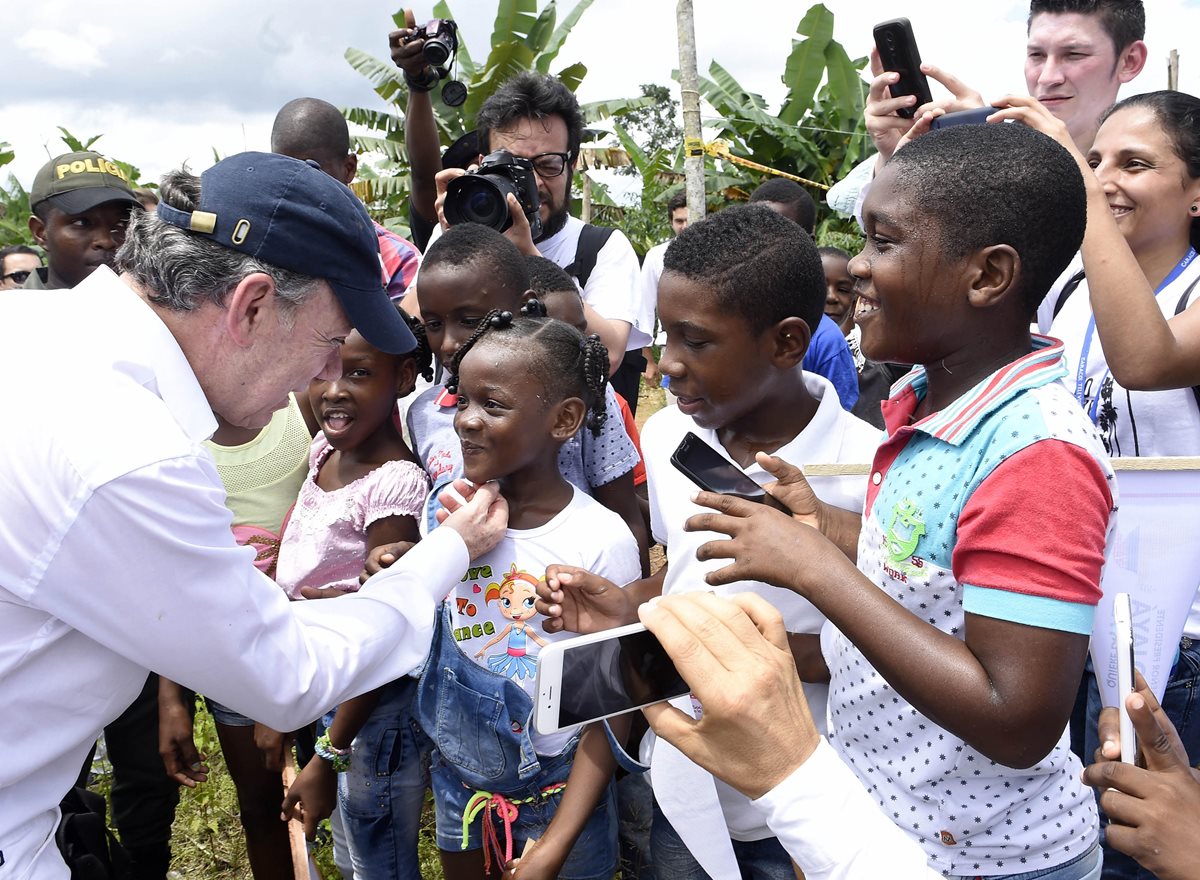 El presidente de Colombia, Juan Manuel Santos, saluda a un grupo de niños en Bojayá. (Foto Prensa Libre: EFE).