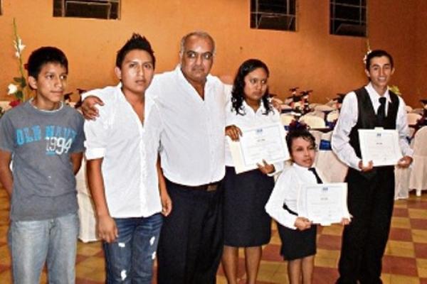 Maestro José Antonio López, rodeado de varios de sus educandos, durante el cierre del ciclo escolar 2013