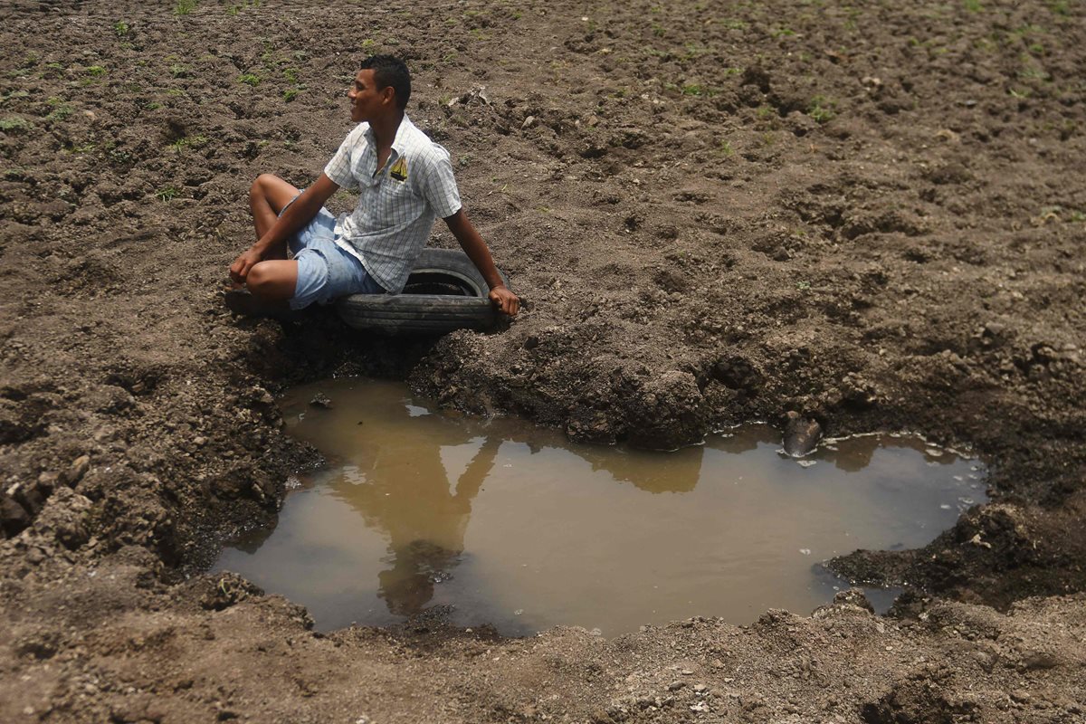 Wilman Estrada, vecino de Atescatempa, Jutiapa, lamenta que la laguna  se haya secado, pues en ella pescaba para ganarse la vida. (Foto Prensa Libre: AFP)