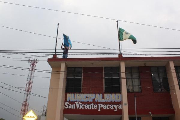 Trabajadores de la municipalidad de San Vicente Pacaya, Escuintla, colocan a media asta las banderas de Guatemala y del municipo. (Foto Prensa Libre: Melvin Sandoval)