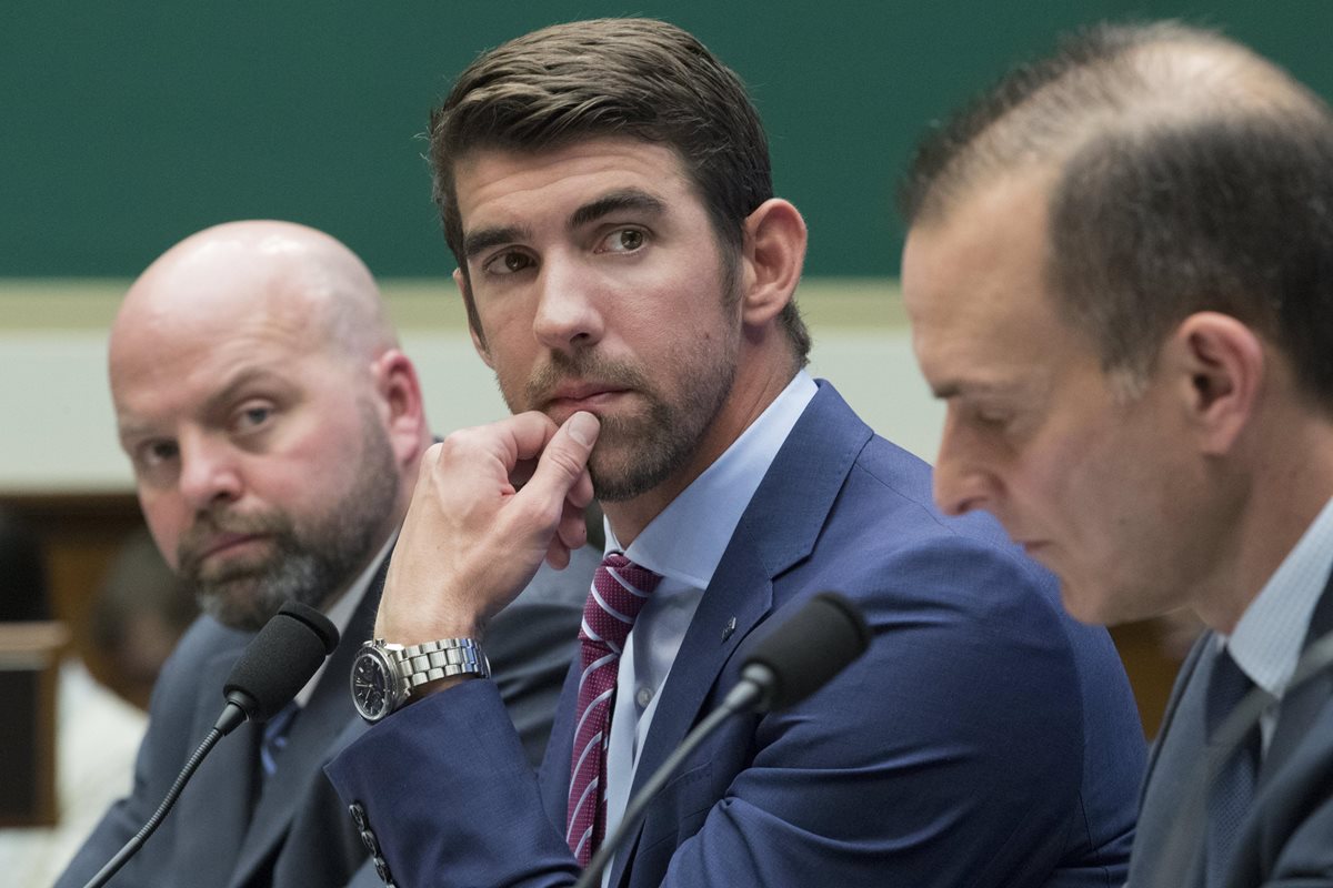 El nadador retirado estadounidense y medallista de oro, Michael Phelps (c), participa junto al lanzador de peso y medallista olímpico y tambíen medallista de oro, Adam Nelson (i), y el director ejecutivo de la Agencia Estadounidense Antidopaje (USADA). (Foto Prensa Libre: EFE)