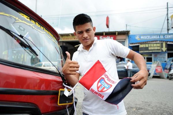 El piloto de un mototaxi coloca la bandera en apoyo al equipo de Heredia. (Foto Prensa Libre: Francisco Sánchez)