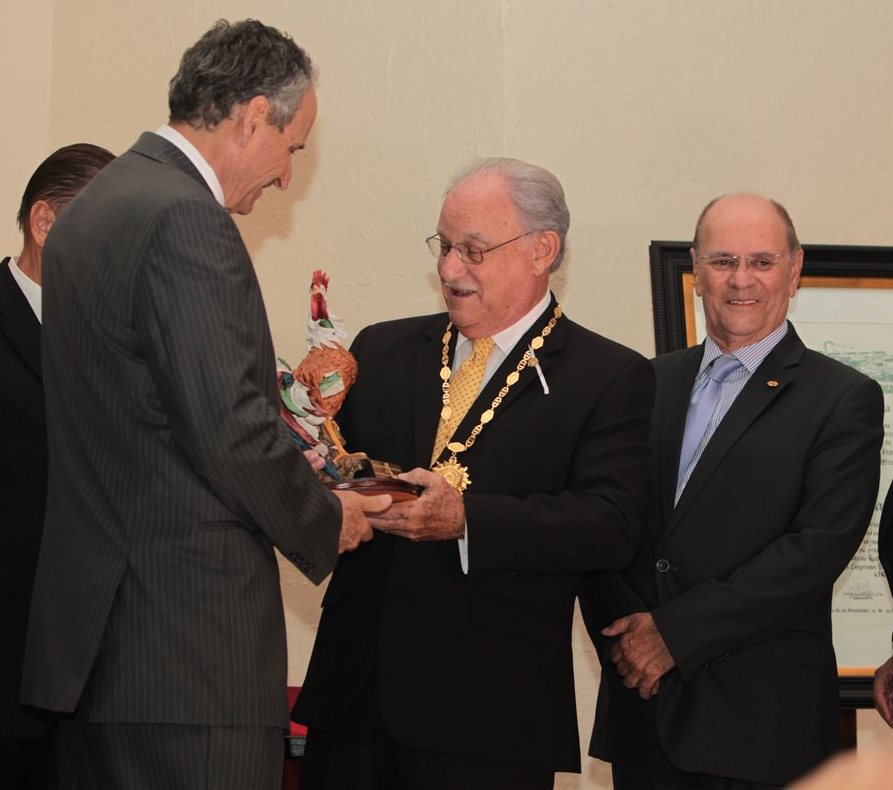 Ricardo Castillo Sinibaldi (al centro) recibe, de manos de Raúl Castillo Zaghi, una figura de gallo que incluye la Orden de Cervecería Centroamericana. A la derecha, Juan Monge Calderón. (Foto Prensa Libre: Edwin Castro)