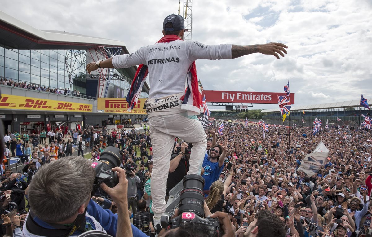 Lewis Hamilton festeja con sus seguidores luego de ganar el Gran Premio de Silverstone. (Foto Prensa Libre: EFE)