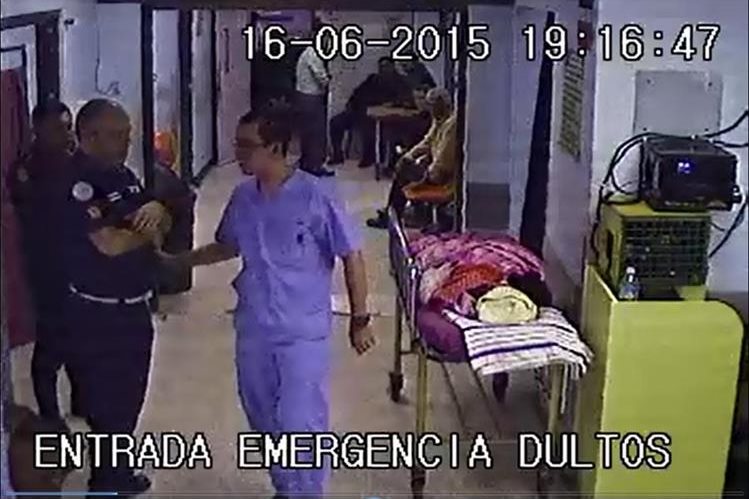 Varios trabajadores  del hospital pasan frente a la paciente y no le prestan atención.