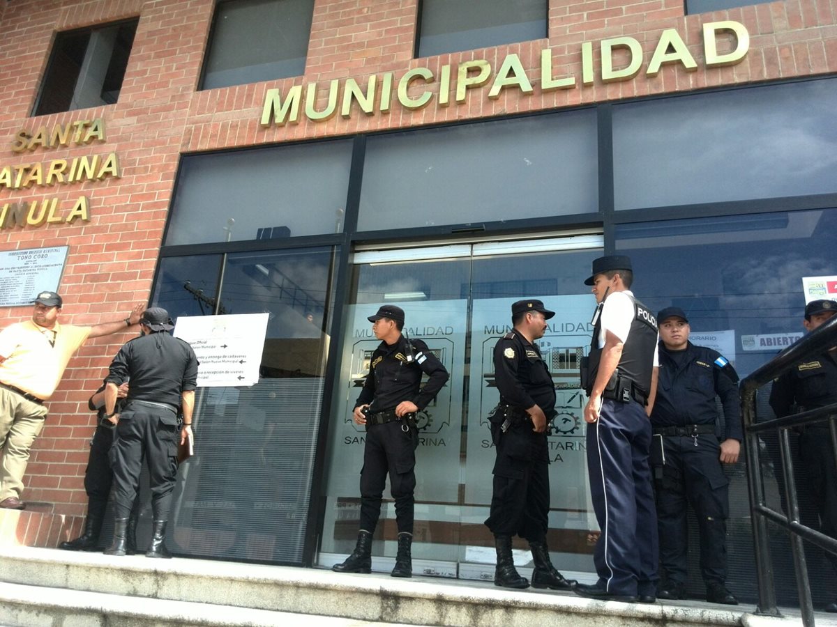 Miembros de la Policía Nacional Civil resguardan el ingreso a la Municipalidad de Santa Catarina Pinula donde se efectúan allanamientos. (Foto Prensa Libre: Estuardo Paredes)