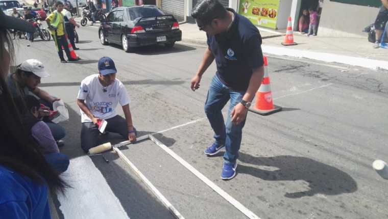 Jóvenes de Ciudad Peronia, Villa Nueva, pintan pasos peatonales en Ciudad Peronia, Villa Nueva, como parte del proyecto, Ponte a Raya. (Foto Prensa Libre: Cortesía Jóvenes Contra la Violencia)